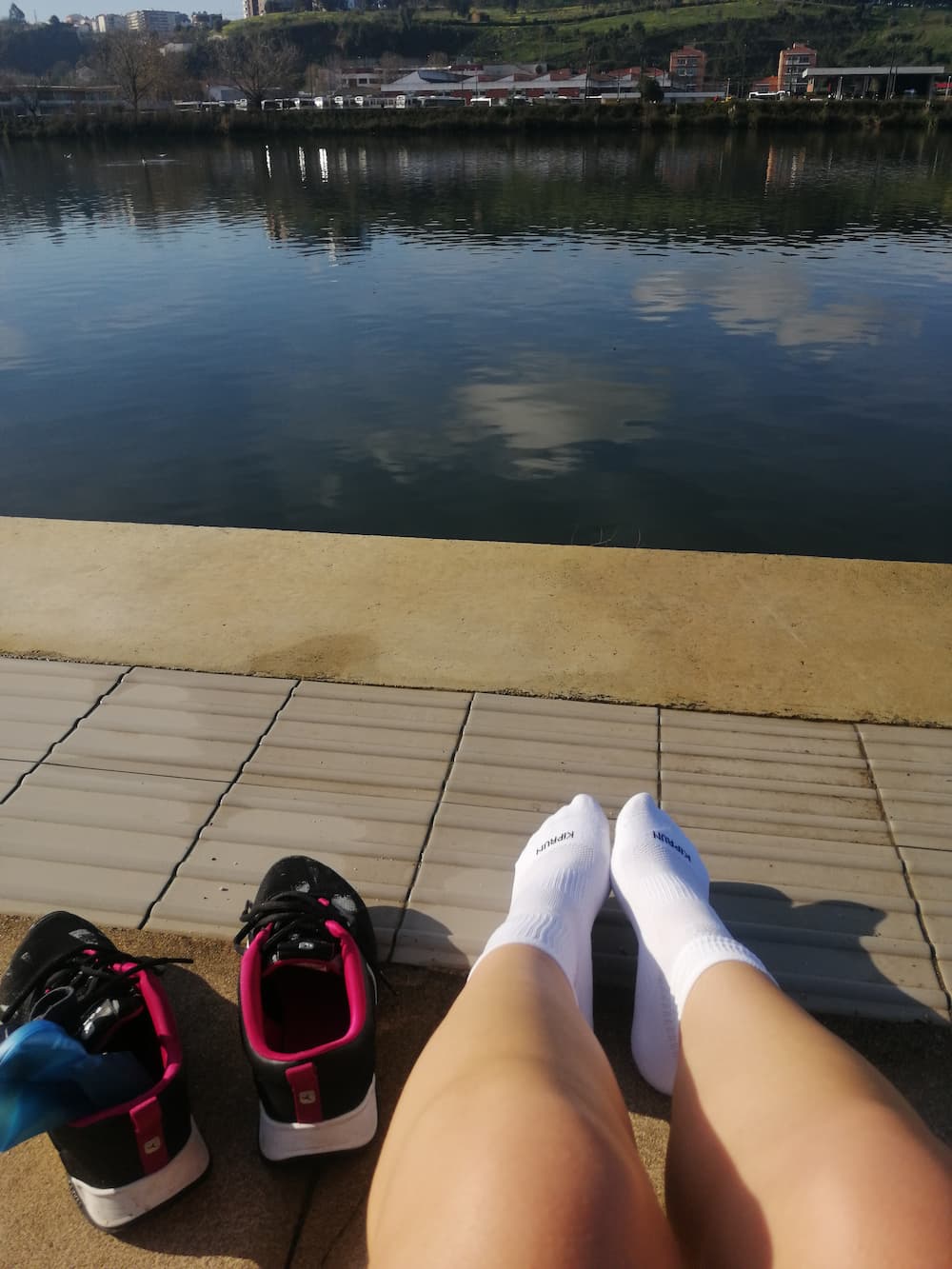 Seated by the river, with the sneakers off, trying to get the blood flowing back to my feet.