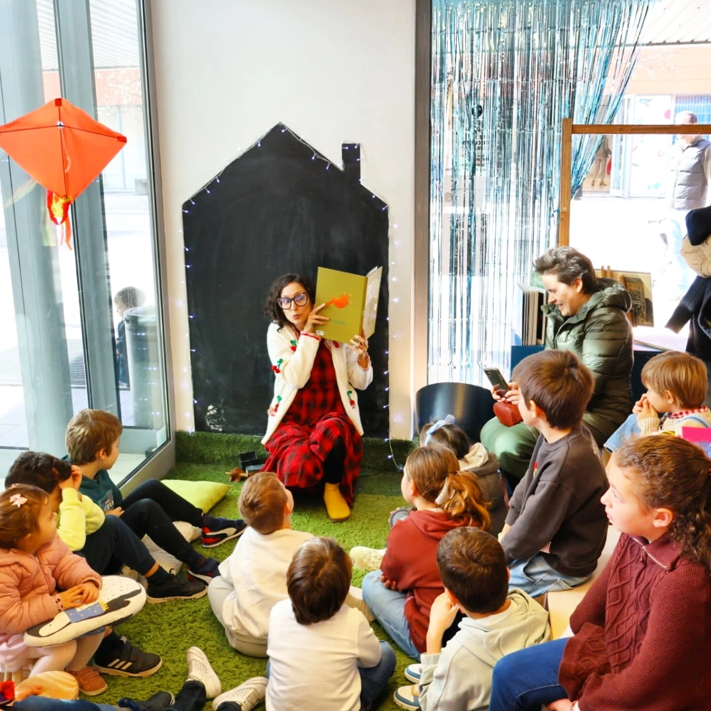 Sofia reading a book to a group of children at Faz de Conto